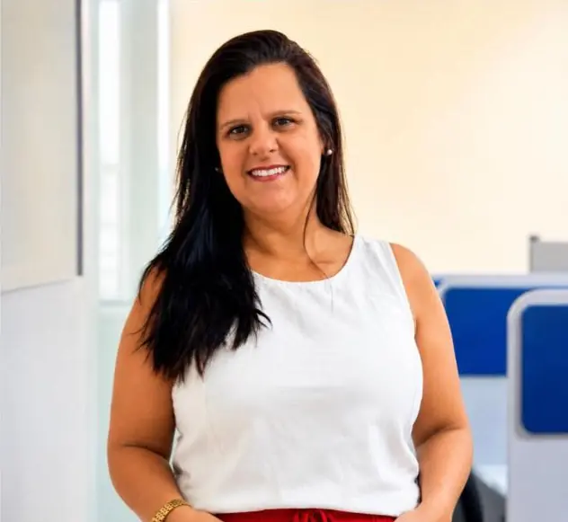 Magna Bernardes, corretora de planos de saúde, sorrindo em seu escritório